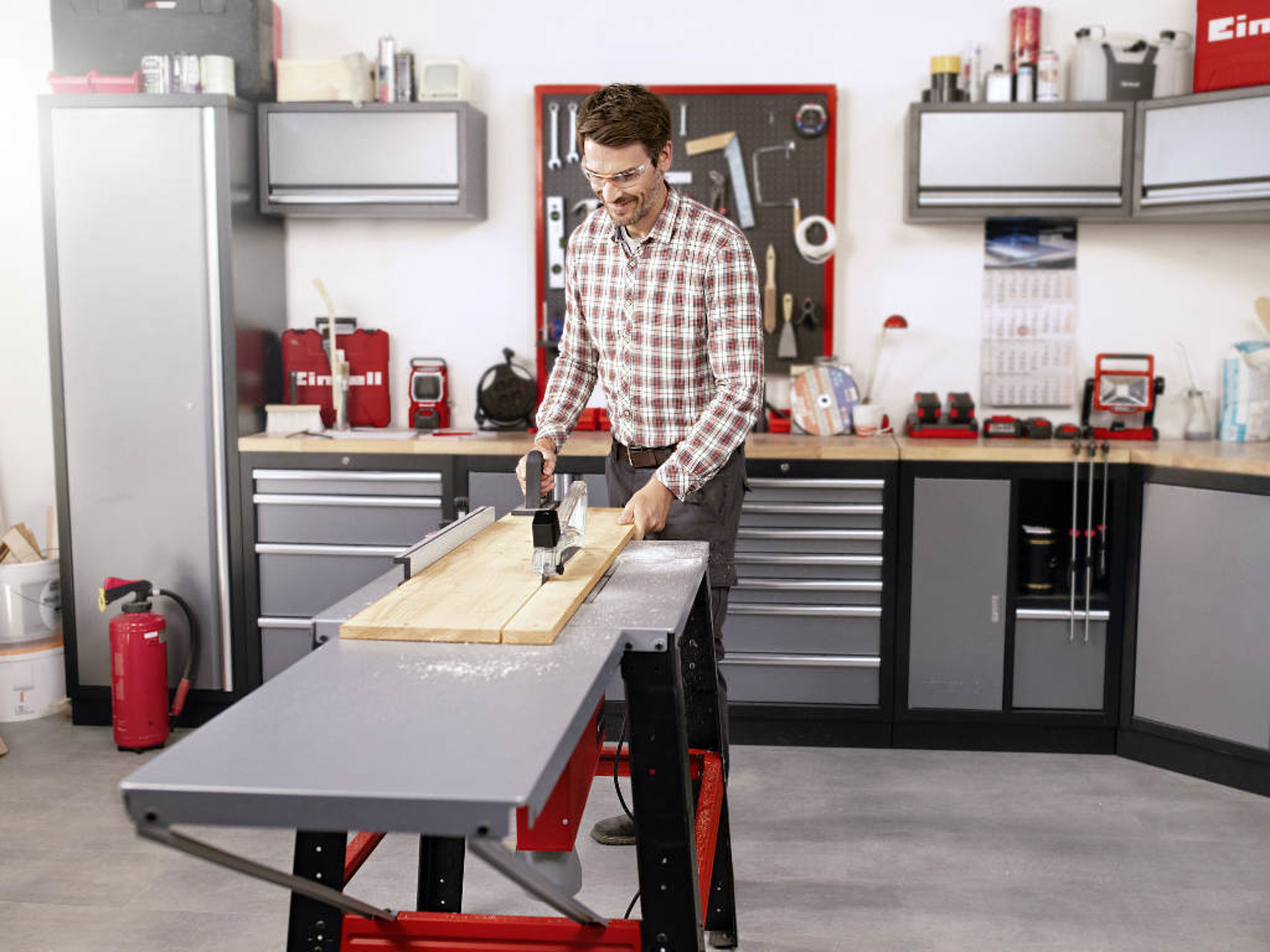 A man cuts a wooden board with an Einhell table saw.