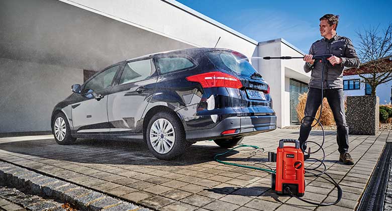 man washing a car with a high pressure cleaner