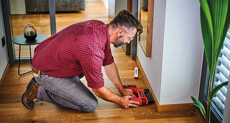 man using a cordless nailer